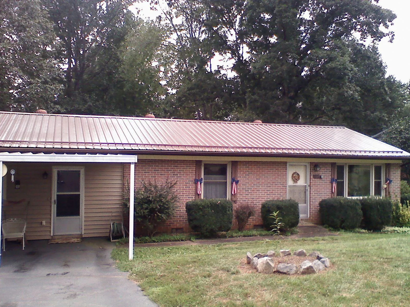 Bronze metal roof and carport on a brick ranch home — Roof Repair work by our crew in Lodi